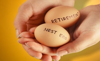 Hands holding two brown eggs. One egg has retirement written on it while the other reads nest egg