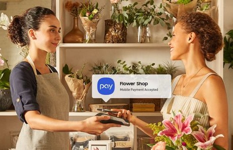Two women using Samsung Pay in a flower shop